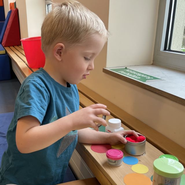 Kind mit Dosen mit unterschiedlichen Inhalten