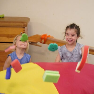 Kinder mit Schwungtuch und Schwämmen