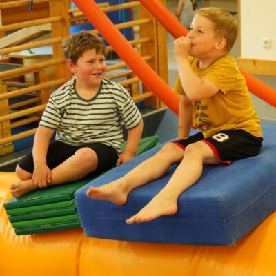 Kinder sitzen auf Hüpfburg und haben Spaß