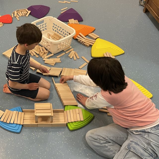 Kinder spielen mit Bauklötzen und Alltagsmaterial
