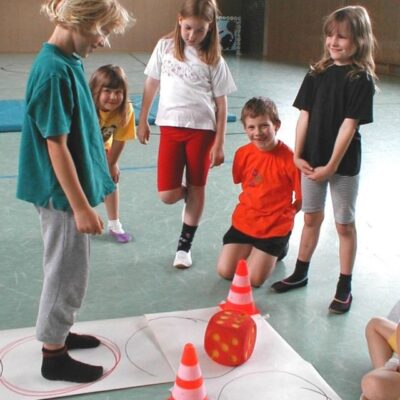Kinder spielen mit Würfel und Kegel