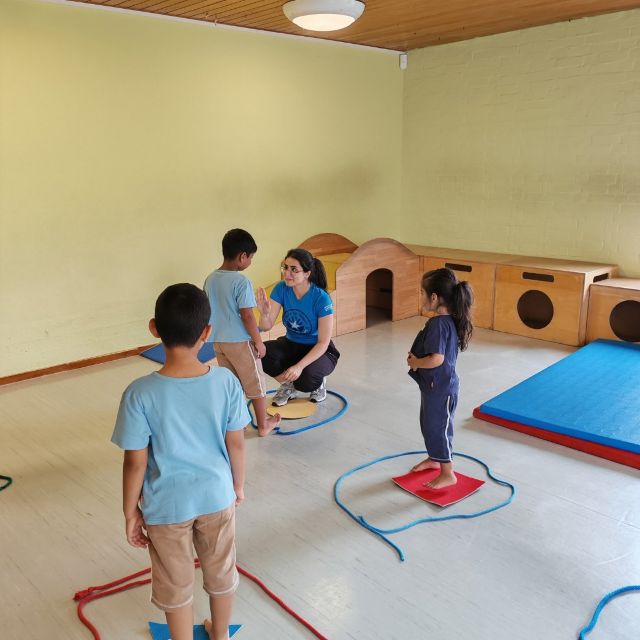 Kinder stehen in Figuren, die aus Seilen erstellt sind